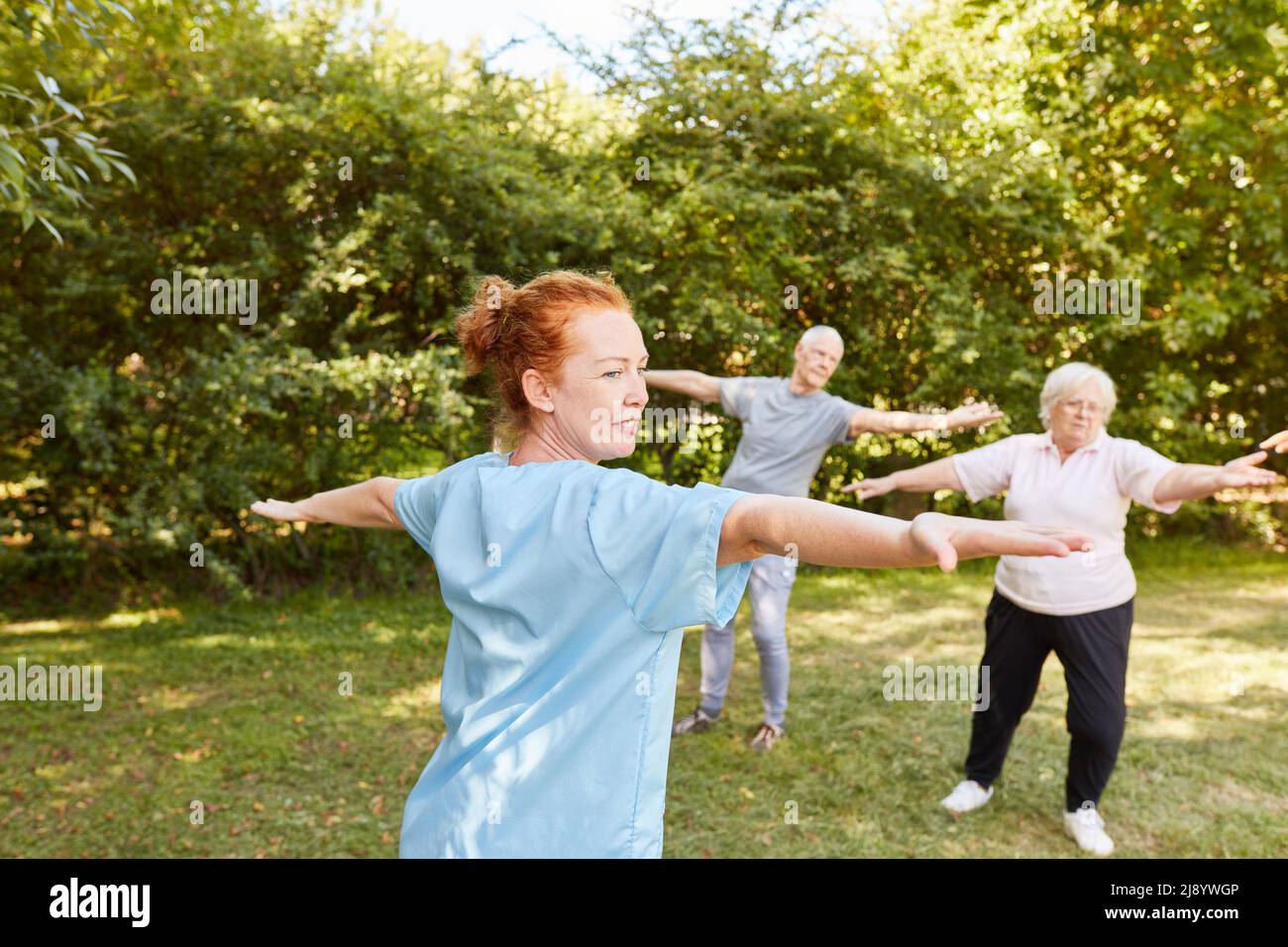 L'istruttore e gli anziani fanno ginnastica nel corso di riabilitazione per il fitness e la salute in età avanzata Foto Stock