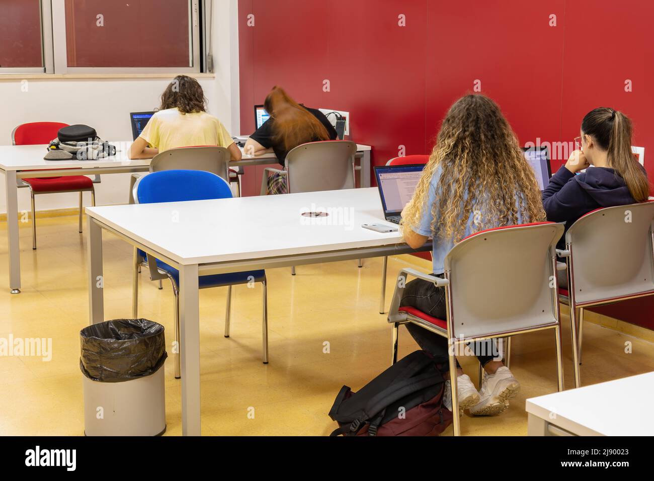 Vista posteriore ed esposizione lunga Fotografia degli studenti che preparano gli esami di notte così, una giovane donna è sfocata per il suo movimento della testa Foto Stock