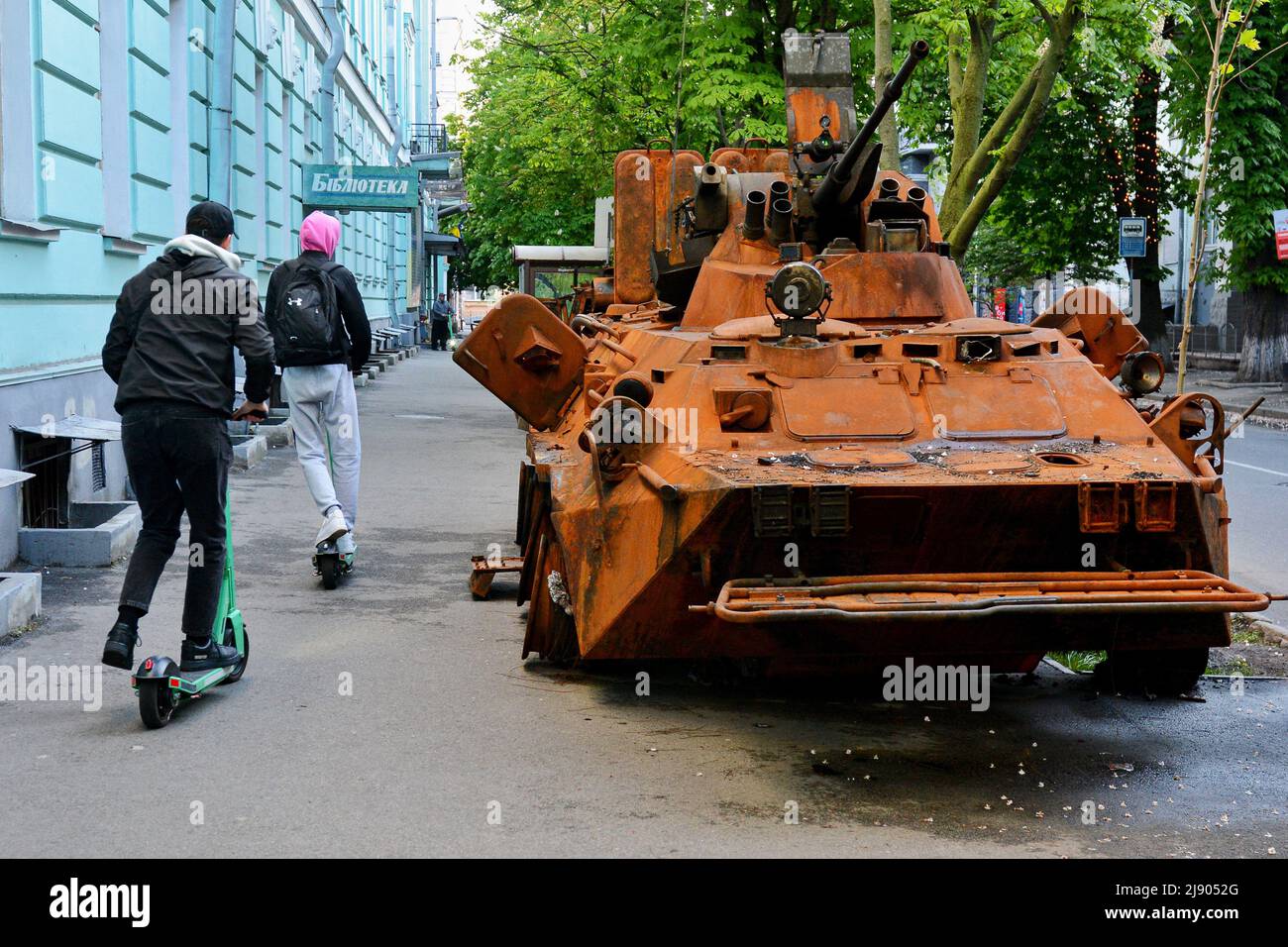 Kiev, Ucraina. 18th maggio 2022. I pedoni sugli scooter passano davanti al portatore di personale corazzato BTR-82A delle forze armate russe nel museo militare di Kyiv, distrutto all'aeroporto Antonov di Gostomel. La Russia ha invaso l'Ucraina il 24 febbraio 2022, scatenando il più grande attacco militare in Europa dalla seconda guerra mondiale Credit: SOPA Images Limited/Alamy Live News Foto Stock