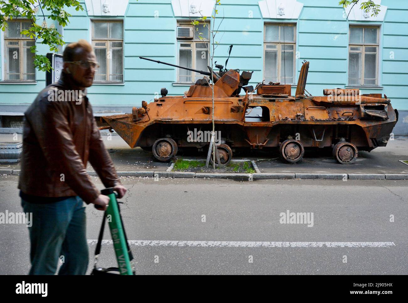 Kiev, Ucraina. 18th maggio 2022. Un uomo su uno scooter corre da un corazzatore personale BTR-82A delle forze armate russe in un museo militare a Kiev, distrutto all'aeroporto Antonov a Gostomel. La Russia ha invaso l'Ucraina il 24 febbraio 2022, scatenando il più grande attacco militare in Europa dalla seconda guerra mondiale (Foto di Aleksandr Gusev/SOPA Images/Sipa USA) Credit: Sipa USA/Alamy Live News Foto Stock