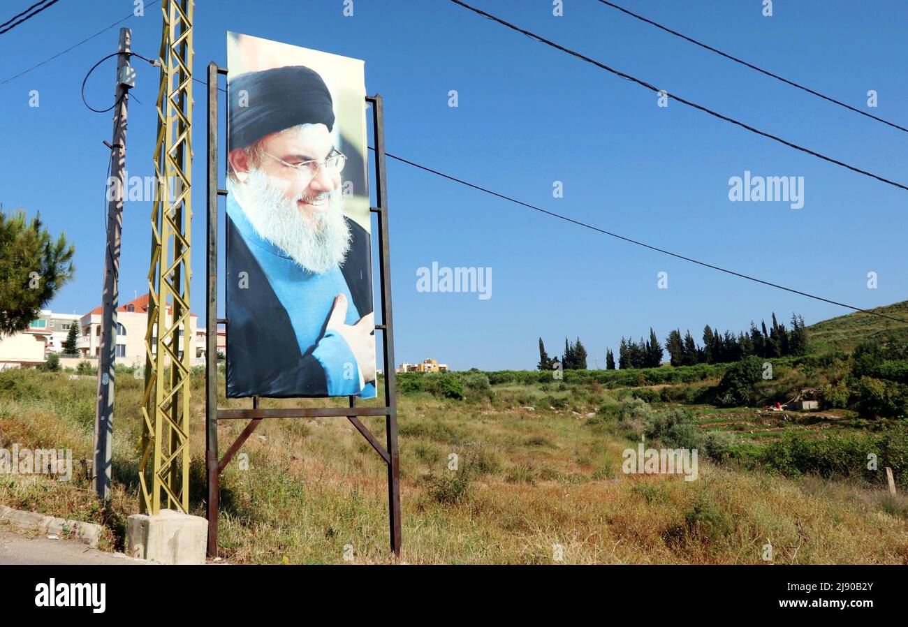 La foto di Hassan Nasrallah è vista nei pressi di Tyr, Libano, il 18 2022 maggio. Il leader di Hezbollah, Hassan Nasrallah, ha dichiarato il 18 maggio sera, in un discorso televisivo sul risultato delle elezioni, che “nessun campo politico del Paese può pretendere di avere una netta maggioranza parlamentare”. Nasrallah ha spiegato che “non è vero che la maggioranza si sia spostata da un luogo all’altro” e che i sostenitori di Hezbollah “hanno ottenuto una vittoria molto grande e dobbiamo esserne orgogliosi alla luce delle circostanze della battaglia”. Nasrallah ha sottolineato che “la resistenza e i suoi alleati hanno una forte e grande presenza nel nuovo parlamento”. M Foto Stock