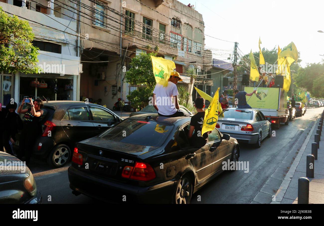 I sostenitori di Hezbollah ondano bandiere a Tyr, in Libano, il 18 2022 maggio. Il leader di Hezbollah, Hassan Nasrallah, ha dichiarato il 18 maggio sera, in un discorso televisivo sul risultato delle elezioni, che “nessun campo politico del Paese può pretendere di avere una netta maggioranza parlamentare”. Nasrallah ha spiegato che “non è vero che la maggioranza si è spostata da un luogo all’altro” e che i sostenitori di Hezbollah “hanno ottenuto una vittoria molto grande e dobbiamo esserne orgogliosi alla luce delle circostanze della battaglia”. Nasrallah ha sottolineato che “la resistenza e i suoi alleati hanno una forte e grande presenza nel nuovo parlamento”. Meanwh Foto Stock