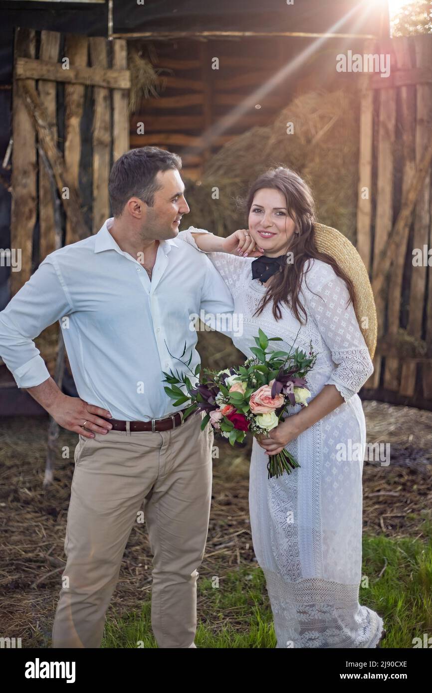 sposa in stile cowboy siede sulla soglia del fienile Foto Stock