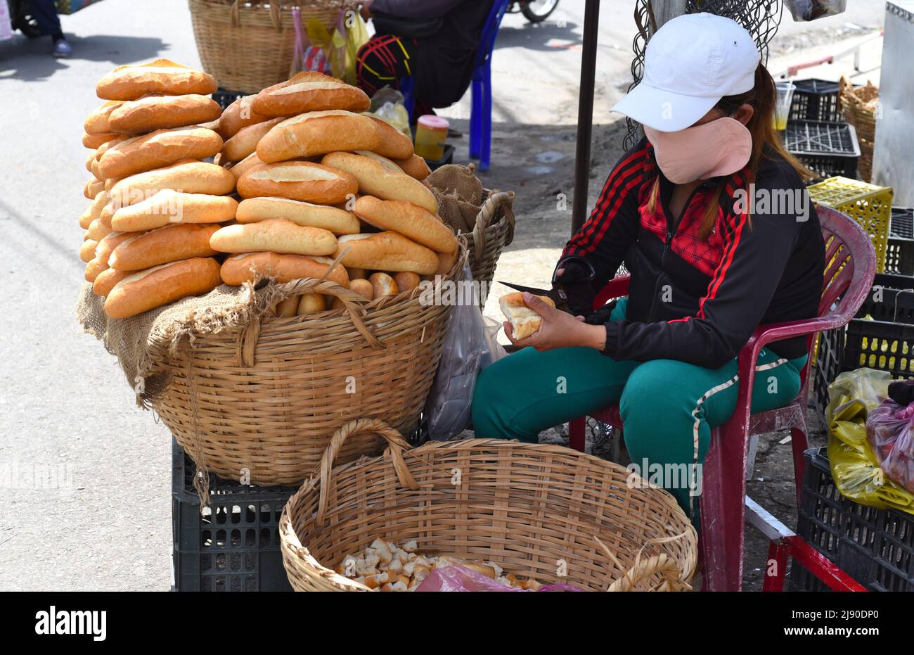 Nha Trang, Vietnam - 17 maggio 2022: Donna vietnamita vende baguette francese sul mercato di Nha Trang Foto Stock
