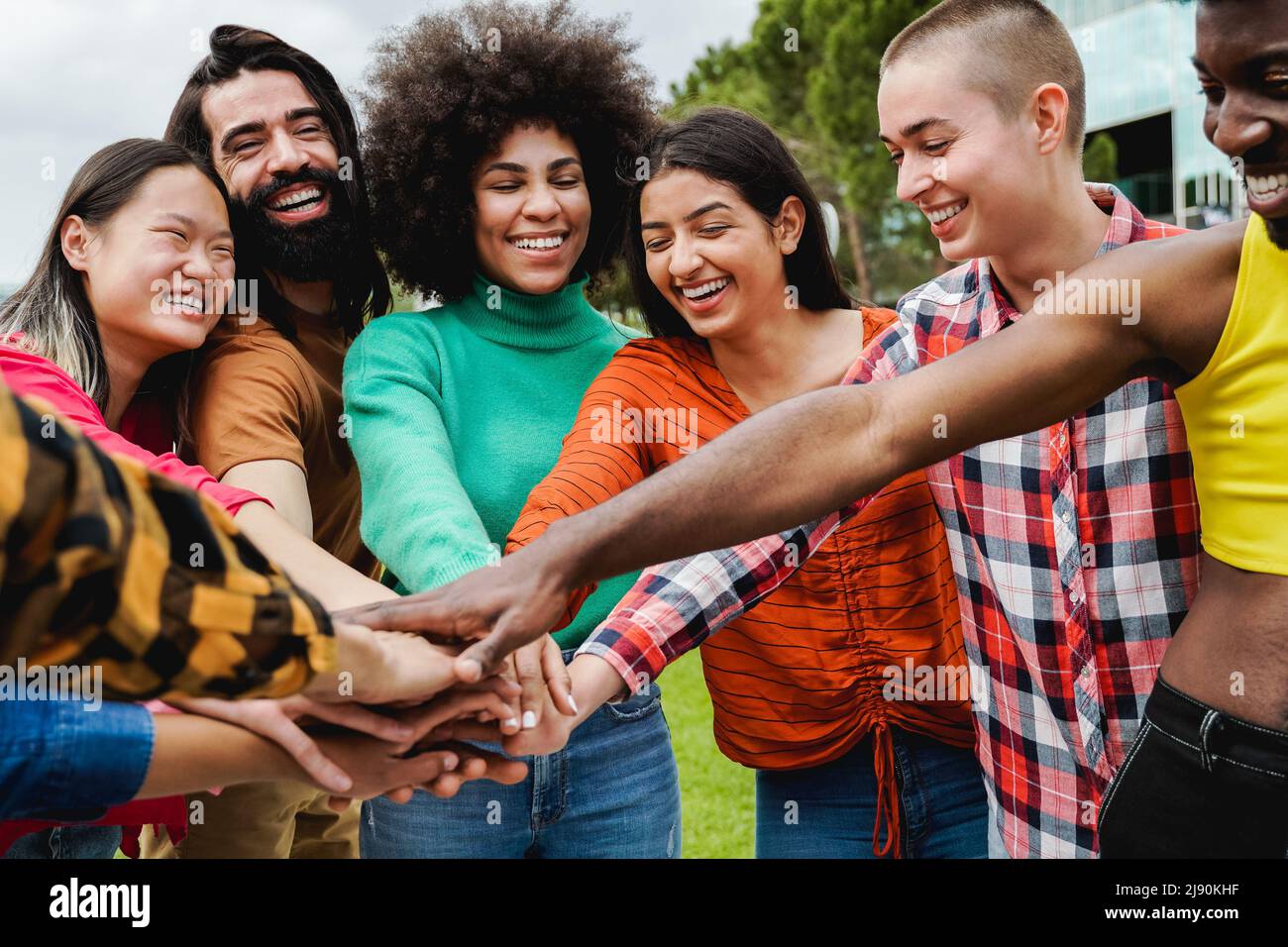 Gruppo giovane multietnico di persone che si accatastano le mani all'aperto - Teamwork diversità e concetto di unità Foto Stock