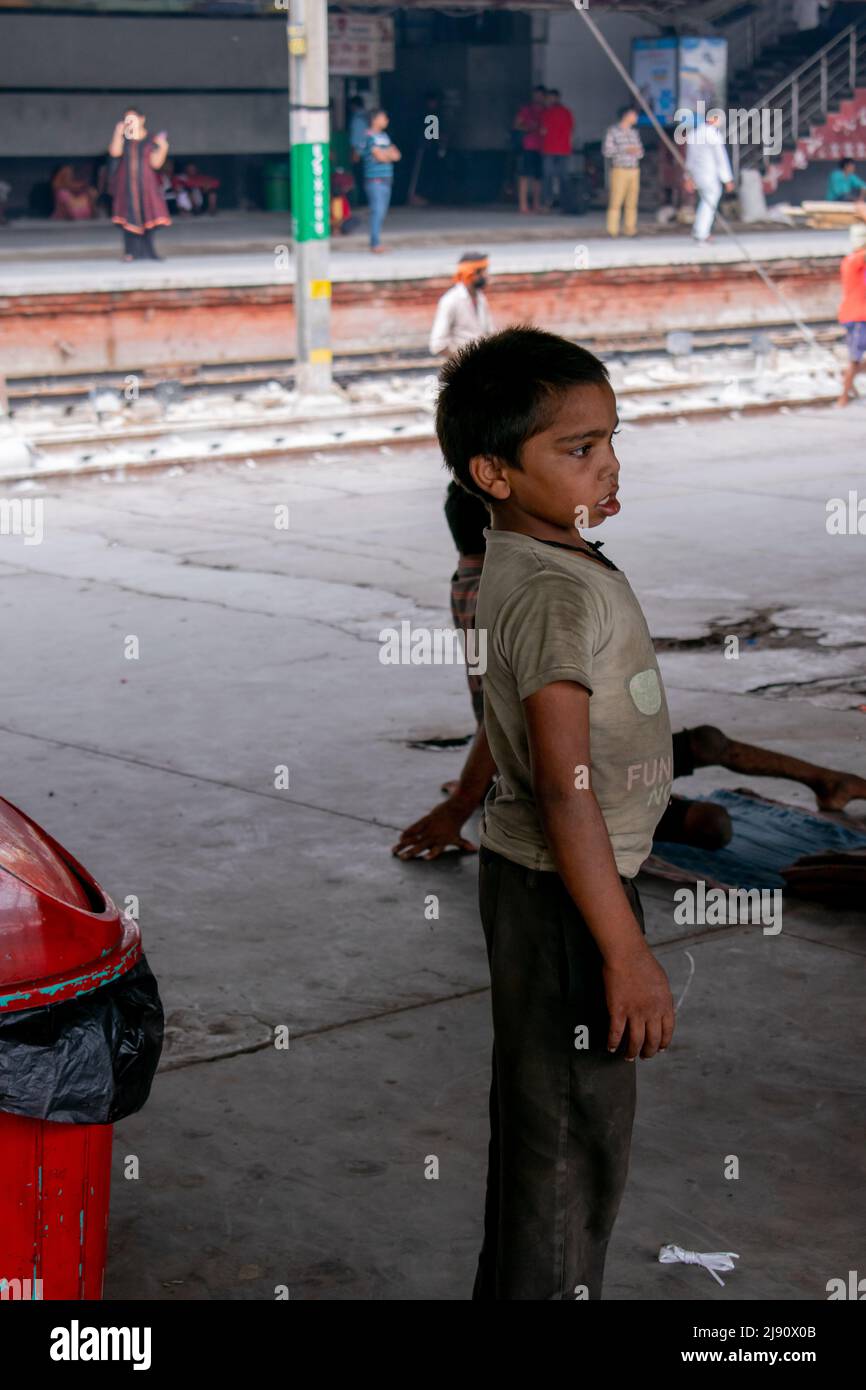 il mendicante indiano si trova in una stazione ferroviaria. Concetto - educazione dei bambini. Foto Stock