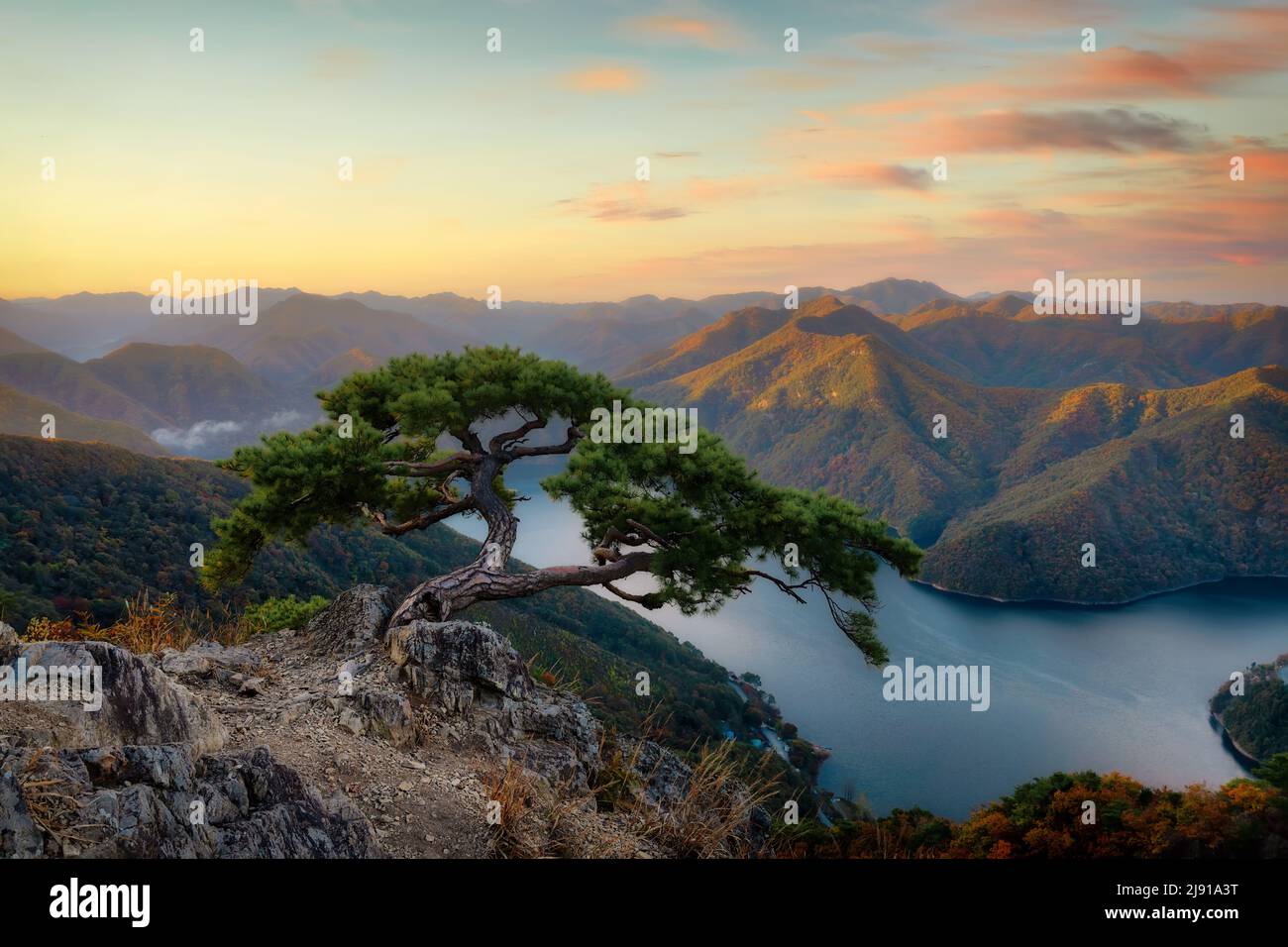 Vista al tramonto di un pino sulla roccia contro Daea Reservoir a Unamsan Mountain vicino Wanju-gun, Corea del Sud , post processato con bracketi di esposizione Foto Stock