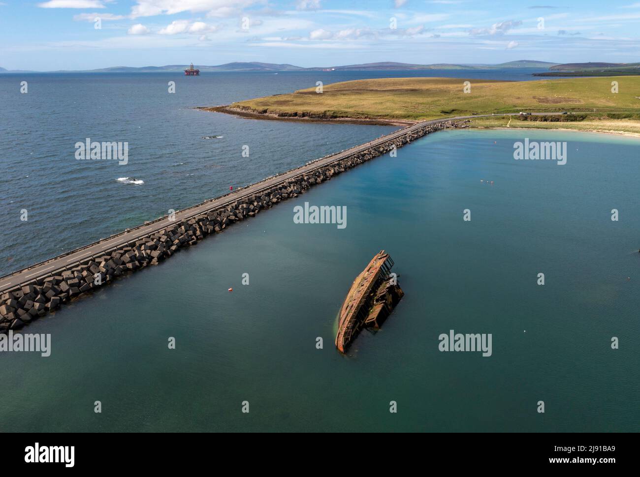Vista aerea della barriera Churchill No.3 e della "nave a blocchi" parzialmente sommersa. I collegamenti di barriera intravedono Holm e Burray, Isole Orkney, Scozia Foto Stock