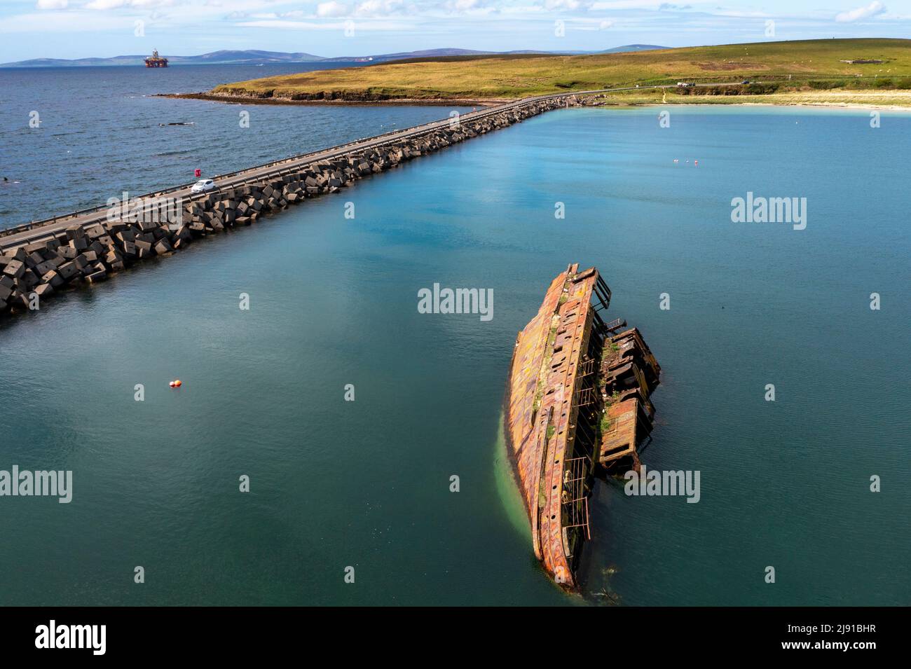 Vista aerea della barriera Churchill No.3 e della "nave a blocchi" parzialmente sommersa. I collegamenti di barriera intravedono Holm e Burray, Isole Orkney, Scozia Foto Stock