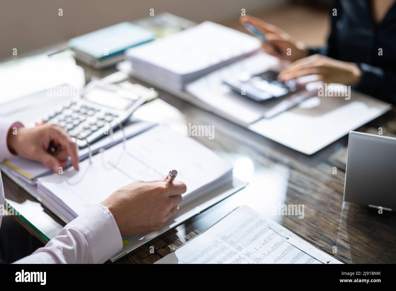 Due colleghi di lavoro Calcolo delle imposte in Office Foto Stock