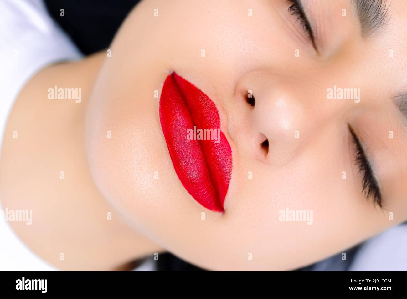 modello con labbra rosse verniciate prima della procedura di trucco permanente del labbro Foto Stock