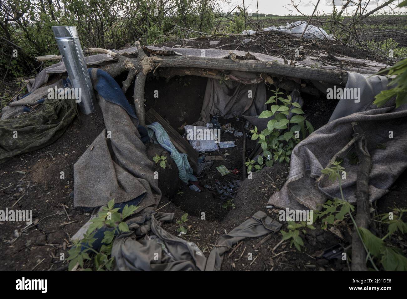 Malaya Rohan, Ucraina. 19th maggio 2022. Gli oggetti personali sono sparsi di fronte a un bunker scavato dai combattenti russi lungo una linea di alberi in Malaya Rohan, Ucraina, mercoledì 18 maggio 2022. I russi usavano questa linea di alberi per attaccare il traffico su una vicina autostrada. La Finlandia e la Svezia hanno formalmente presentato domande di adesione all'alleanza militare della NATO all'inizio di mercoledì, ponendo fine ai decenni di neutralità militare dei paesi nordici sulla scia della guerra della Russia in Ucraina. Foto di Ken Cedeno/UPI Credit: UPI/Alamy Live News Foto Stock