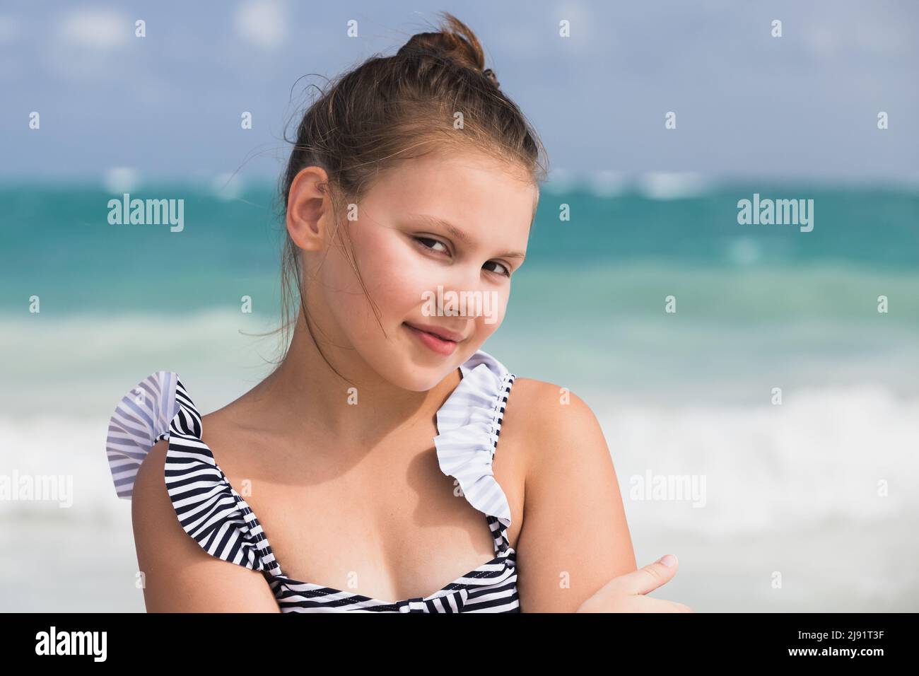 Ritratto di bella bambina in costume da bagno preso alla costa dell'oceano. Foto all'aperto scattate in una giornata di sole Foto Stock
