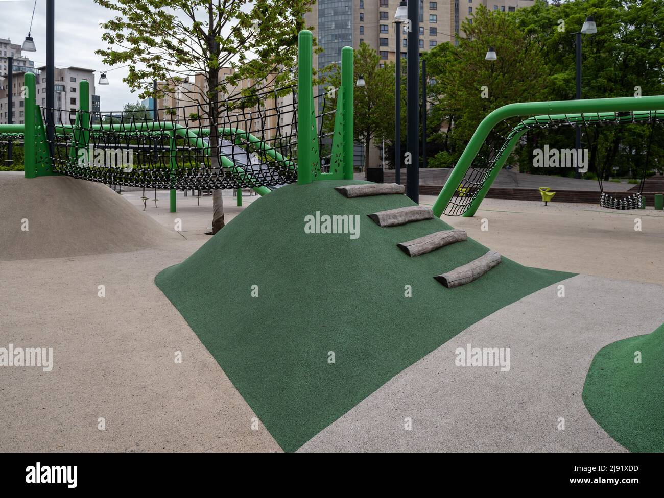 Parco giochi per bambini nel cortile di alti edifici. Foto Stock