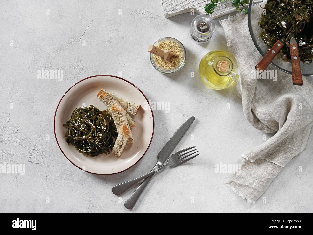 insalata di alga laminaria con semi di sesamo e olio. Pranzo o cena tradizionale. Usato per mangiare con i bastoni del pane. Crudo, vegano, vegetariano cibo sano Foto Stock