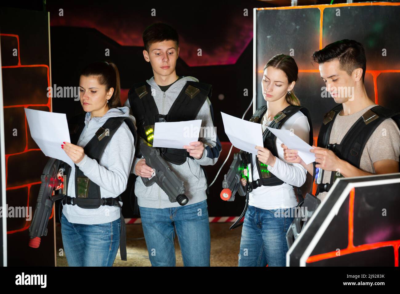 Gruppo di giocatori laser tag leggere un contratto e condizioni di gioco Foto Stock