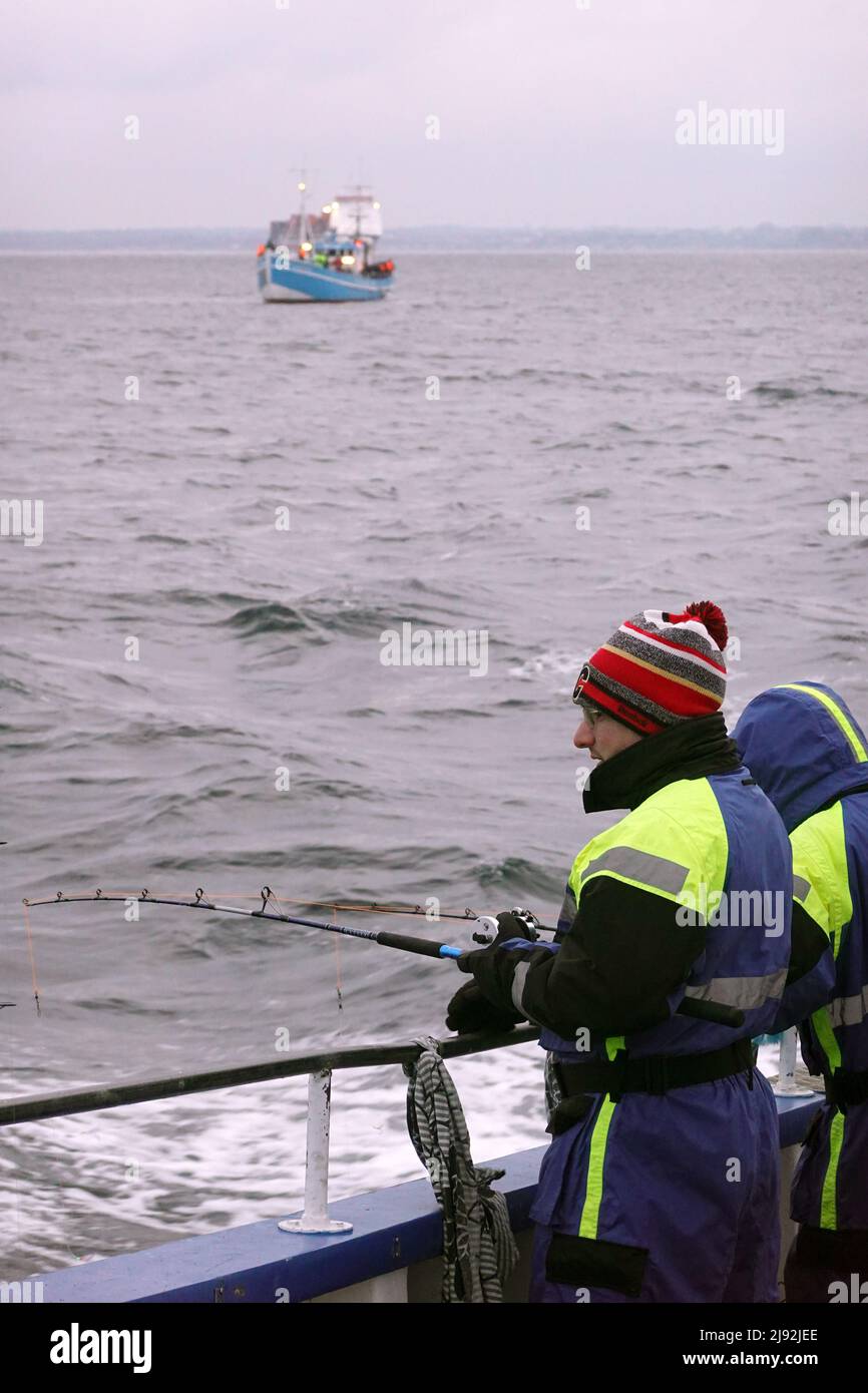 08.01.2022, Helsingborg, Skane laen, Svezia - uomini di pesca d'altura sul Mar Baltico. 00S220108D686CAROEX.JPG [RELEASE MODELLO: NO, RELEASE PROPRIETÀ: NO Foto Stock