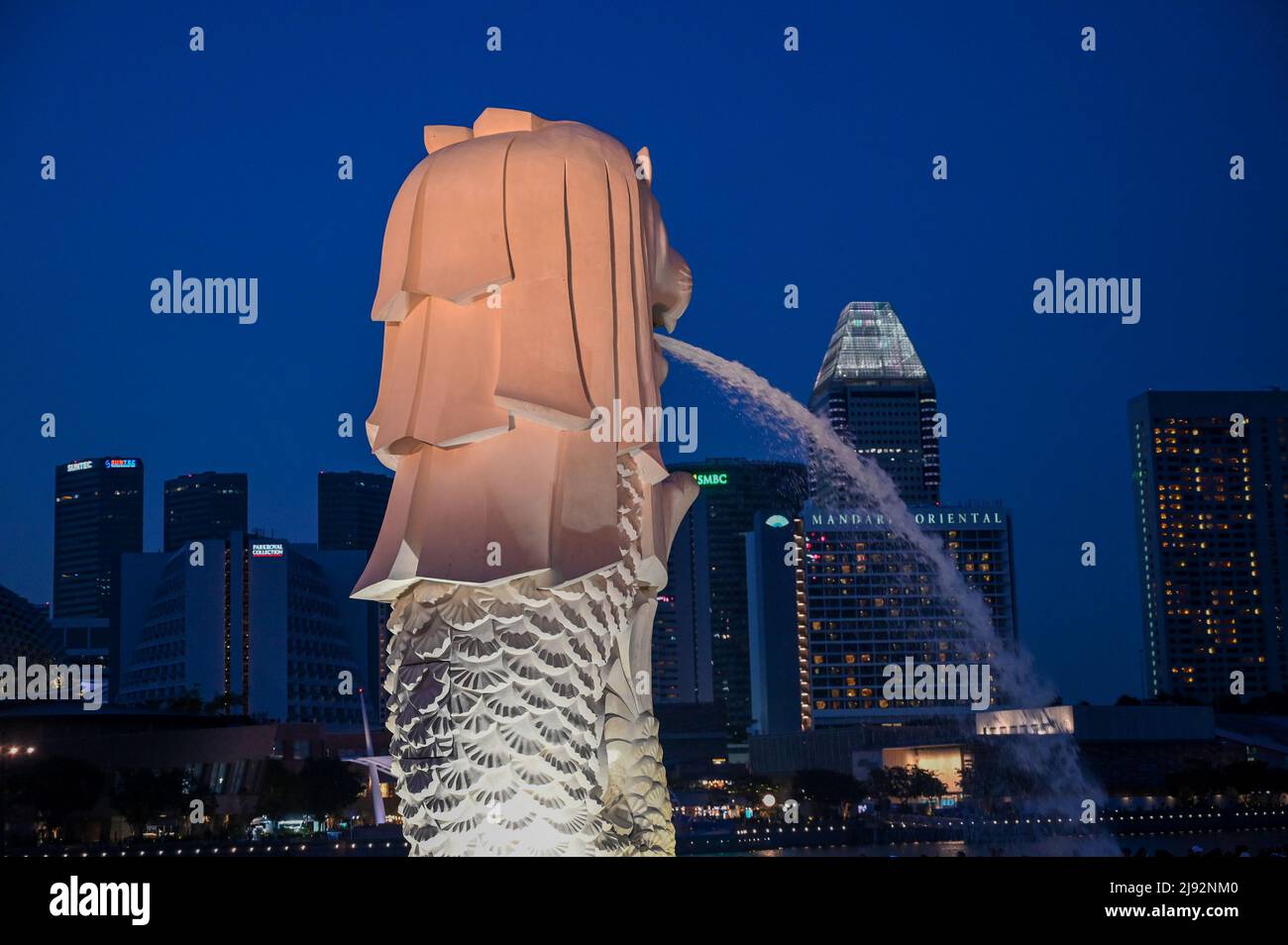 Merlion Park, una statua iconica di Singapore di notte. Merlion è una creatura mitica con la testa di un leone e il corpo di un pesce Foto Stock