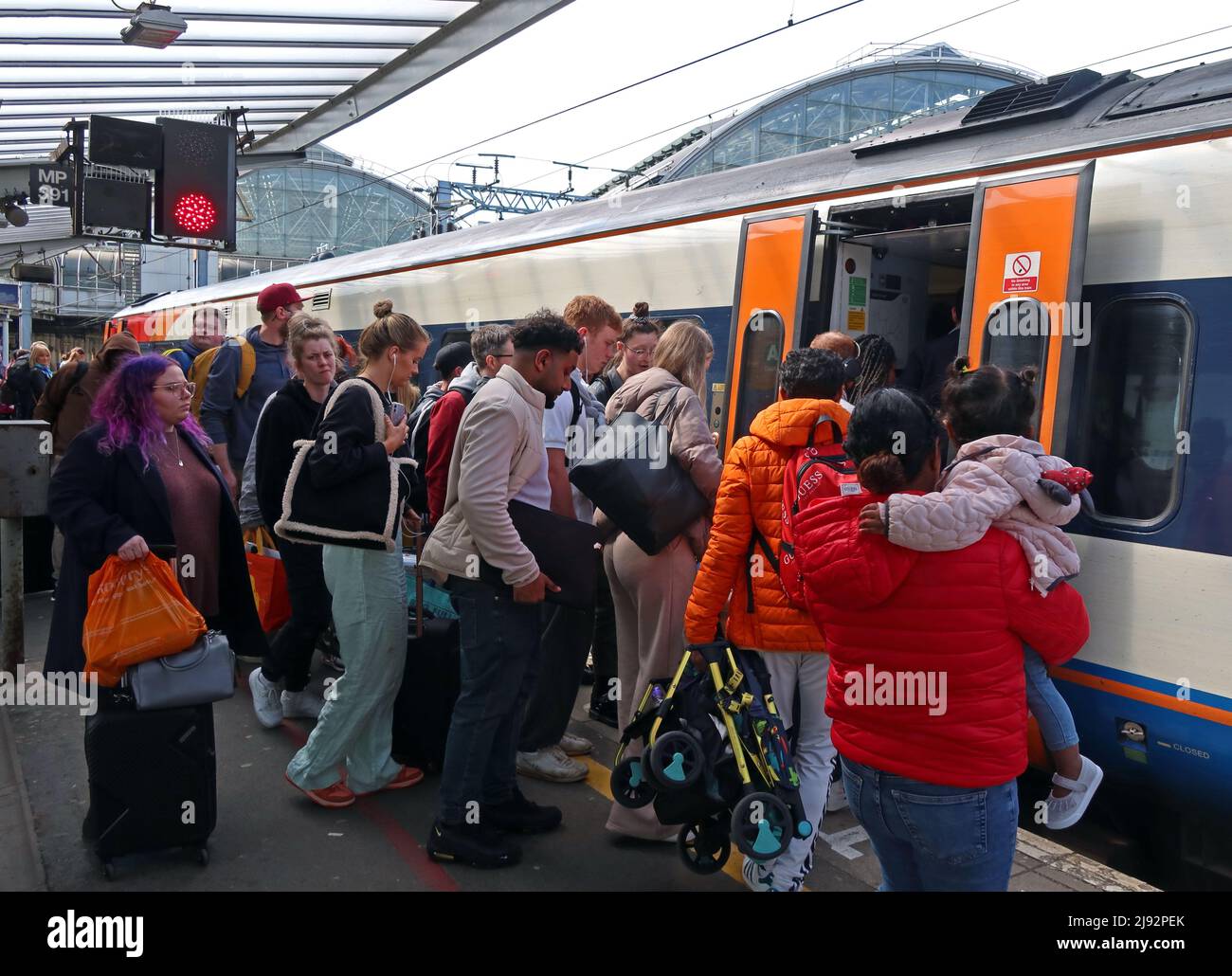 Una folla di passeggeri, sale a Norwich EMR East Midlands Railway DMU treno 57865 a Piccadilly Station, Manchester, Inghilterra, Regno Unito Foto Stock