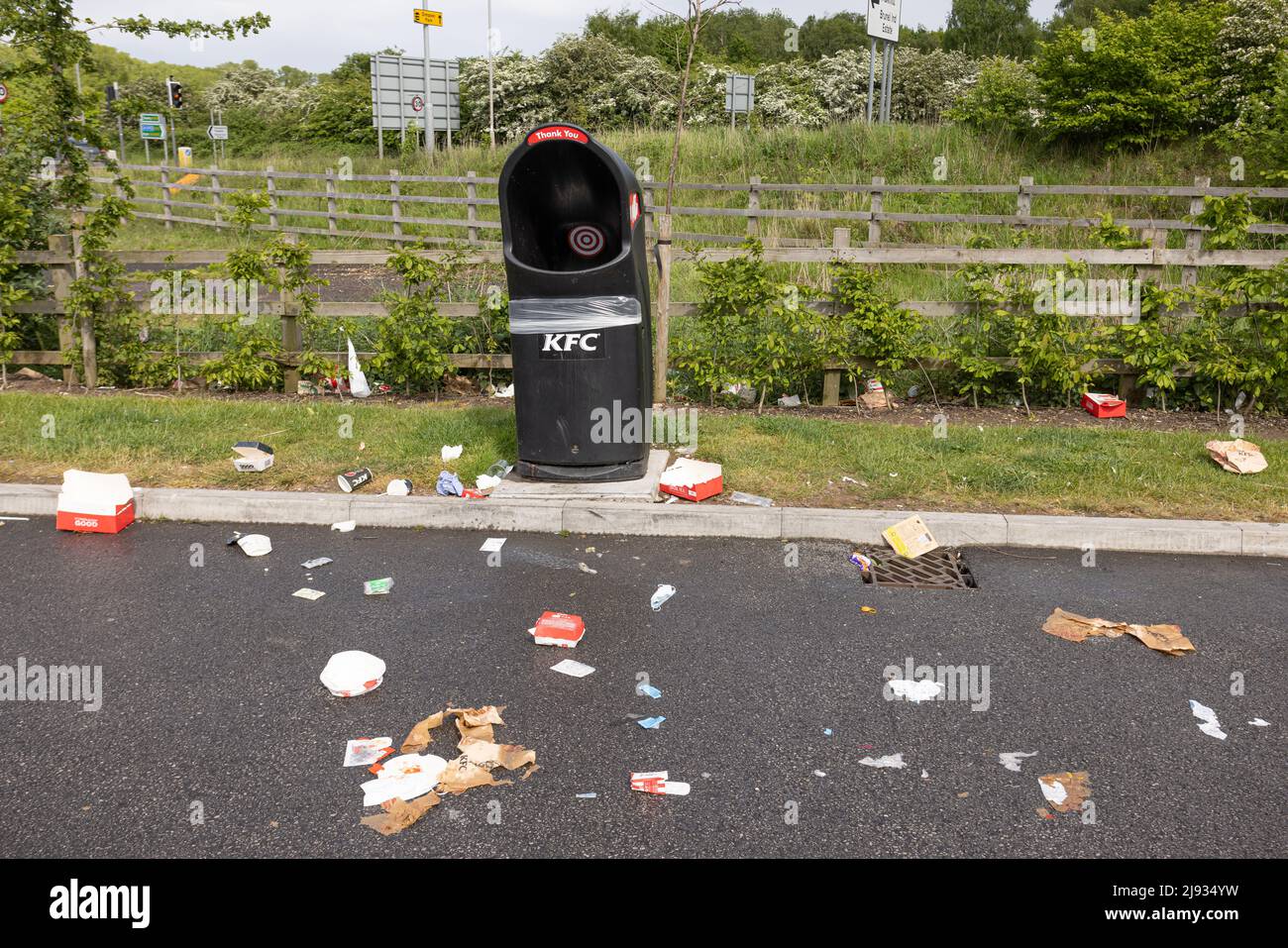 Cestino sulla strada pubblica. Cestino e spazzatura KFC tutto intorno contenitore vuoto del thrash Foto Stock