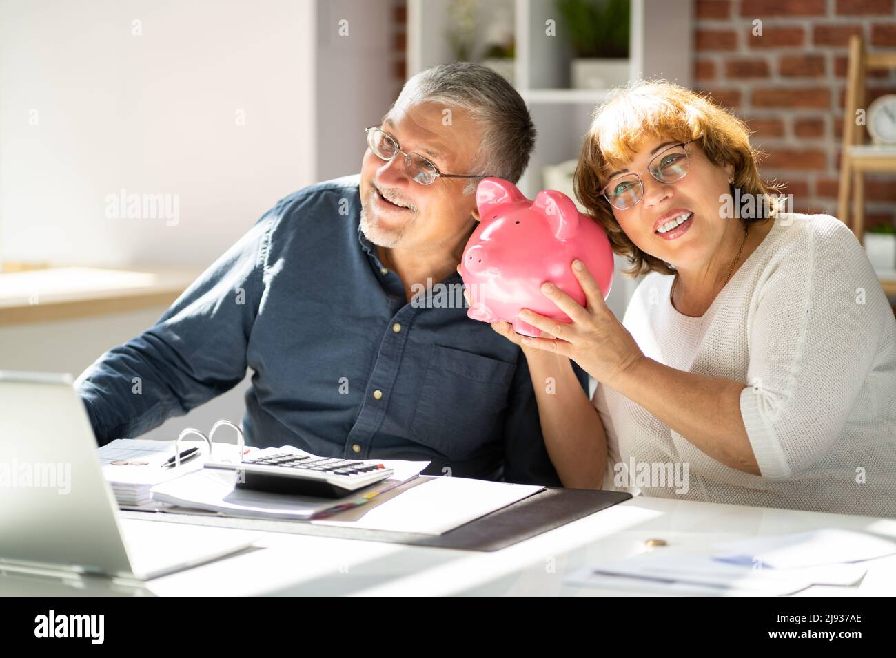 Giovane Uomo cerca Donna a inserimento di moneta in Piggybank Foto Stock