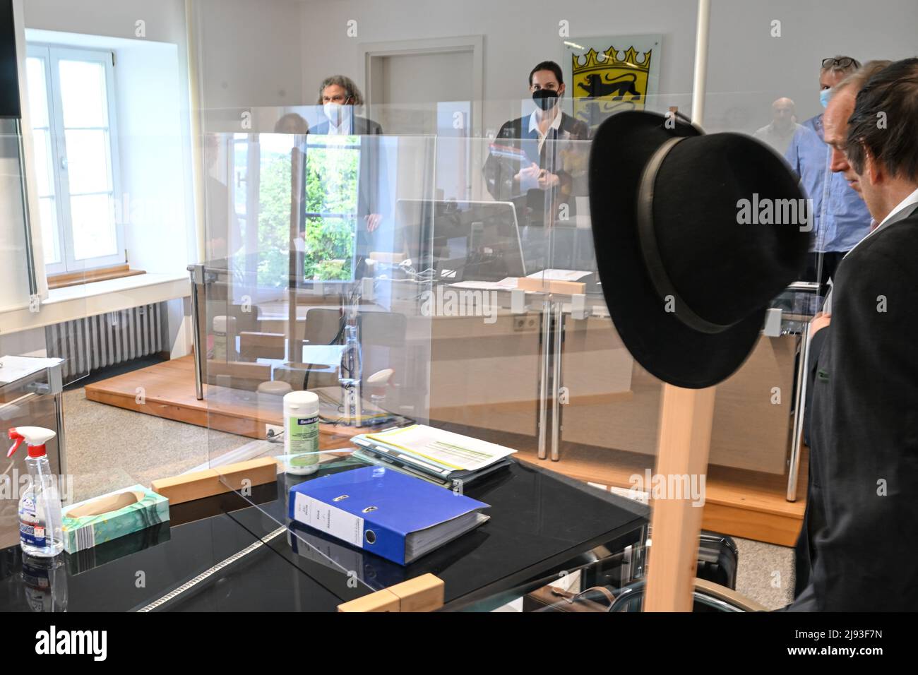 Ravensburg, Germania. 20th maggio 2022. Il cappello di un coltivatore di frutta convenuto (r) è appeso al posto di una partizione nel tribunale del tribunale del lavoro. I lavoratori del raccolto georgiani hanno presentato una causa contro l'azienda di frutta per i salari trattenuti. Il caso riguarda essenzialmente la questione se i lavoratori del raccolto abbiano diritto al salario minimo anche se il datore di lavoro non li utilizza, ad esempio, a causa del maltempo. Credit: Felix Kästle/dpa/Alamy Live News Foto Stock