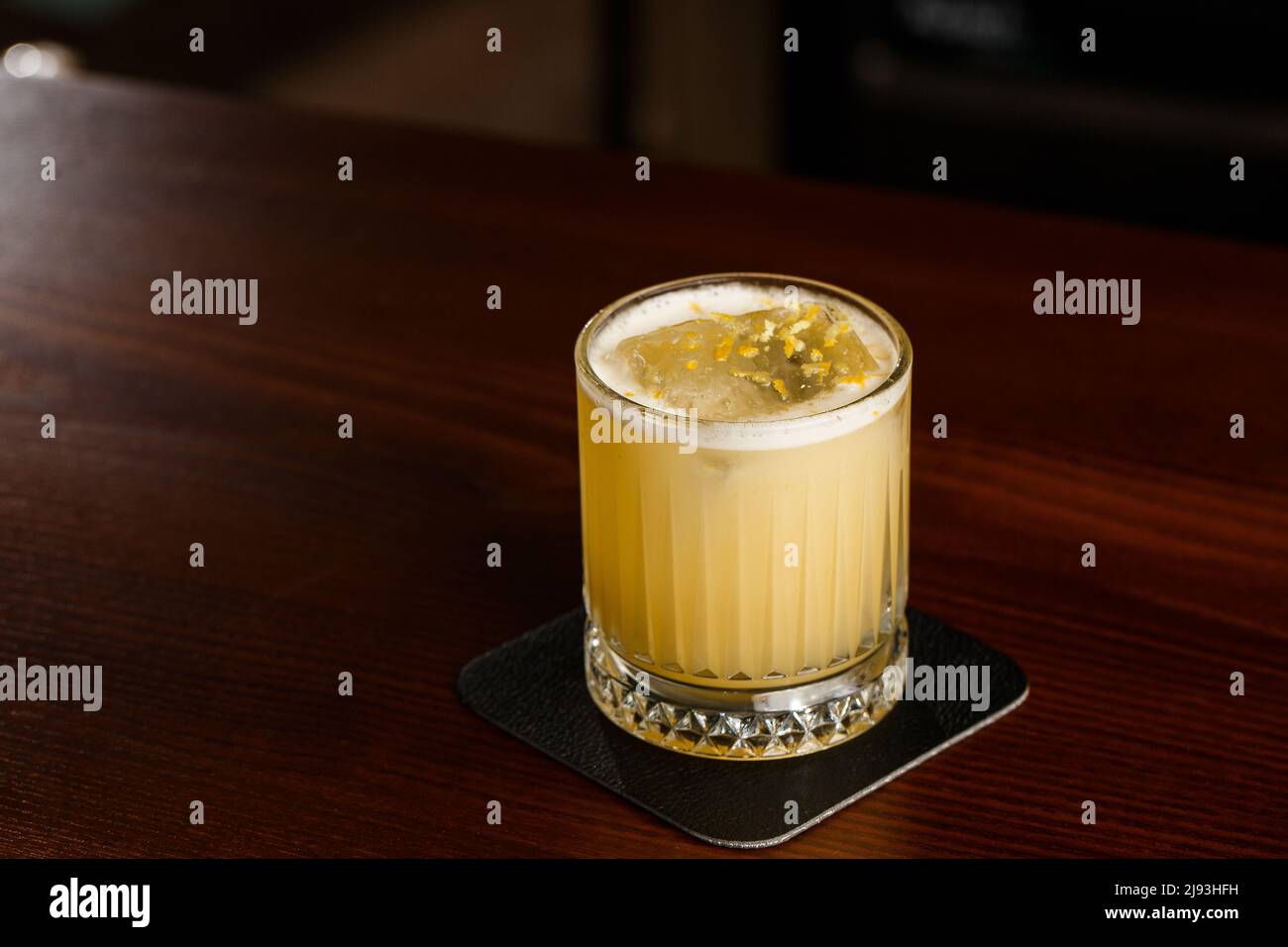 Bevanda alcolica di Scotch Whiskey Penicillin cocktail con limone, sciroppo di miele e zenzero candeen. Bicchiere da cocktail su sfondo nero. Foto Stock