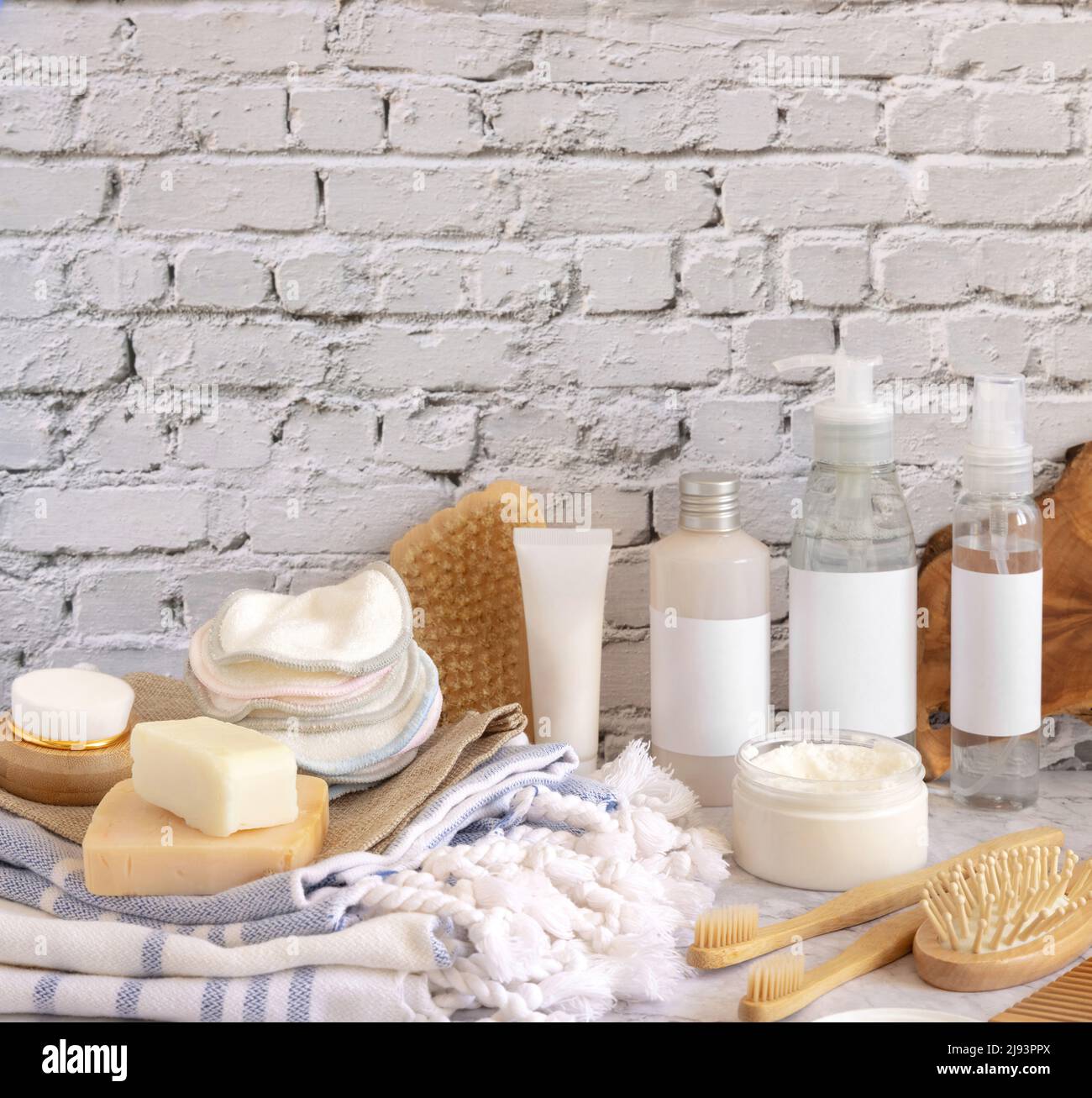 Cosmetici fatti in casa per la cura della pelle e accessori da bagno contro muro di mattoni bianchi primo piano. Mockup di imballaggio del marchio. Prodotti biologici di bellezza. Concetto di Home Spa Foto Stock