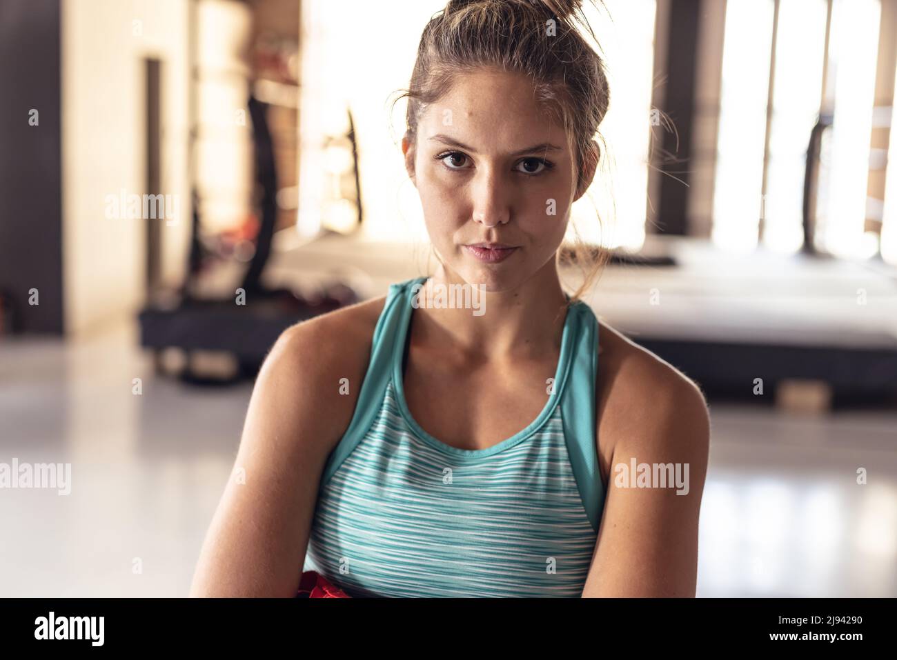 Ritratto di sicuro caucasico giovane donna boxer indossando blu canotta in piedi in Health club Foto Stock