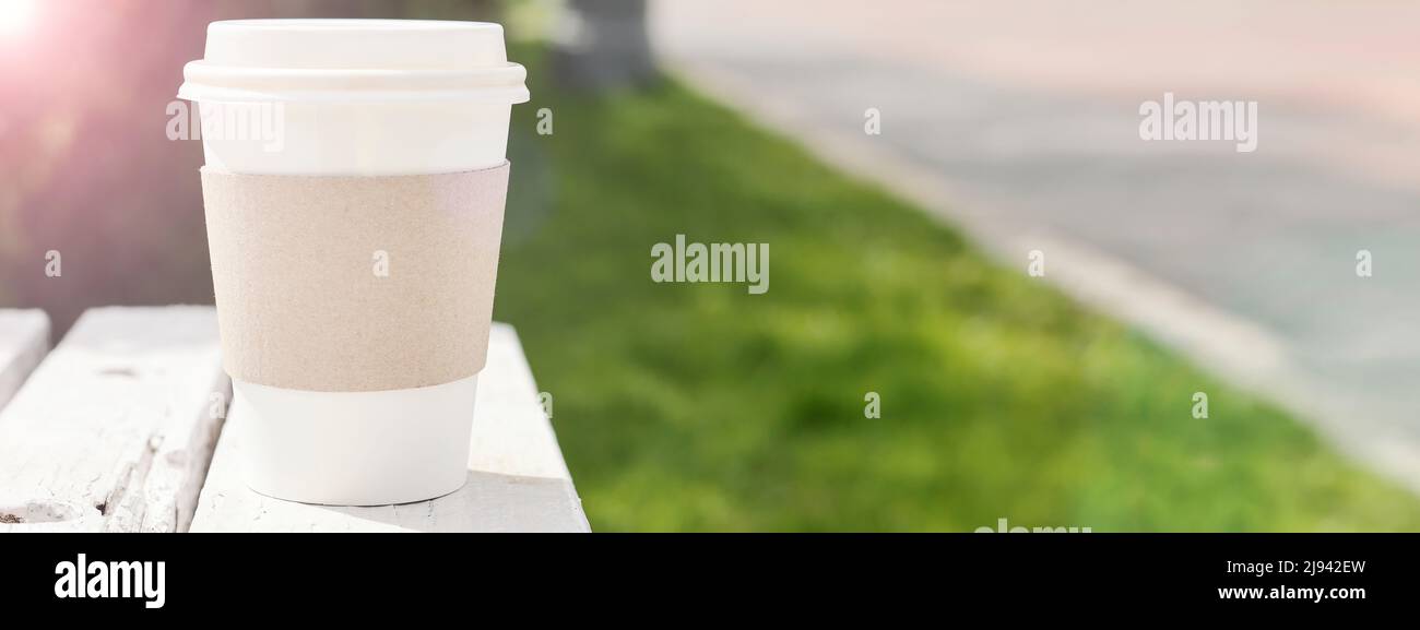 Mockup di take away usa e getta contenitore di carta da caffè o tazza su strada. Spazio copia. Minimal , ecologia , stile di vita concetto. Fuoco selettivo banner Foto Stock