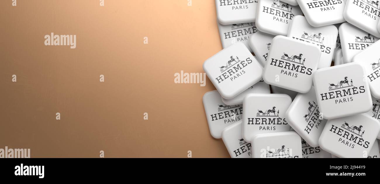 Logo del marchio di lusso Hermès su un mucchio su un tavolo. Spazio di copia. Formato banner Web. Foto Stock