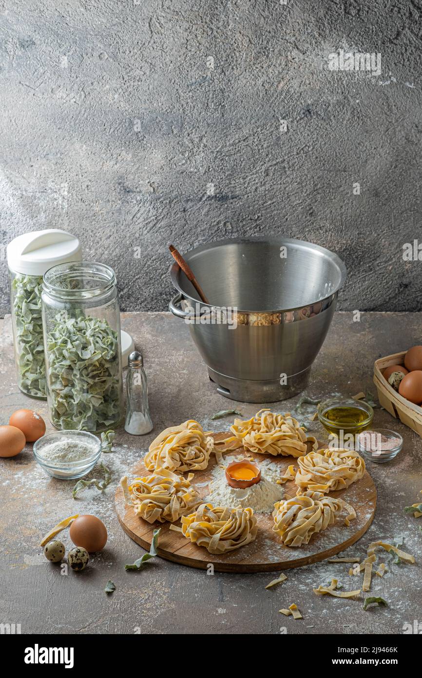 Tagliatelle appena fatte con uova e farina su tavola di legno Foto Stock