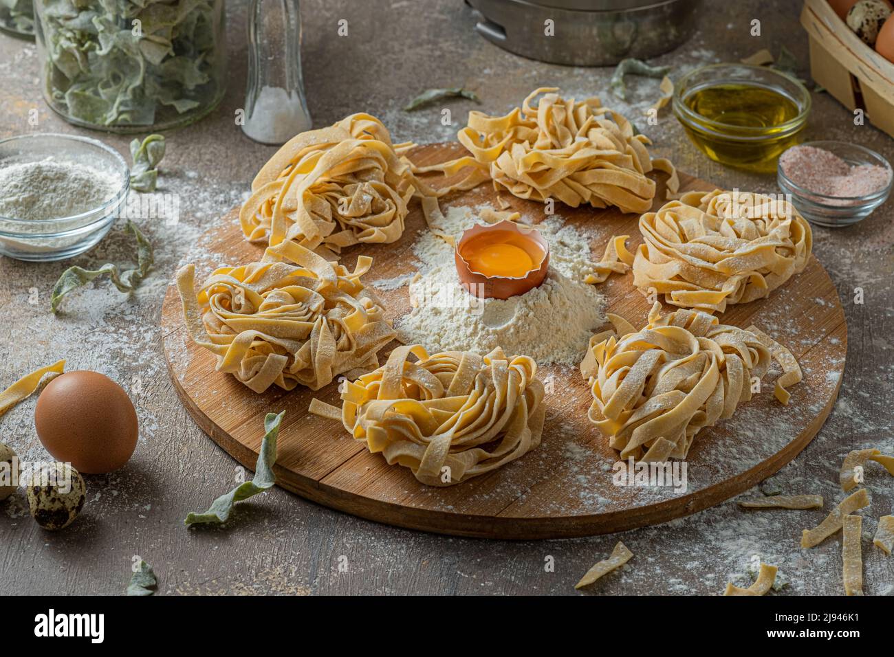 Tagliatelle appena fatte con uova e farina su tavola di legno Foto Stock