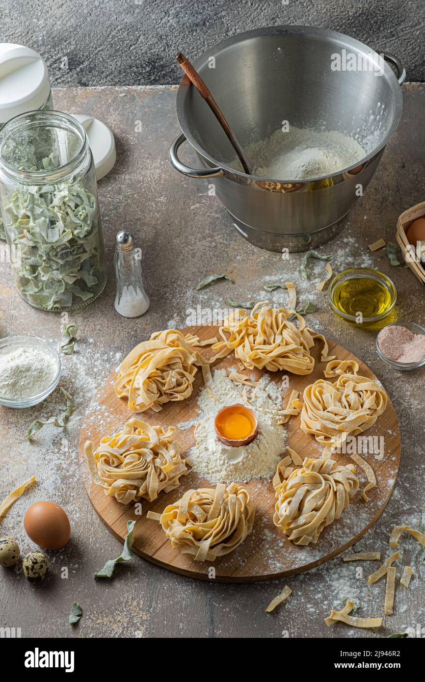 Tagliatelle appena fatte con uova e farina su tavola di legno Foto Stock