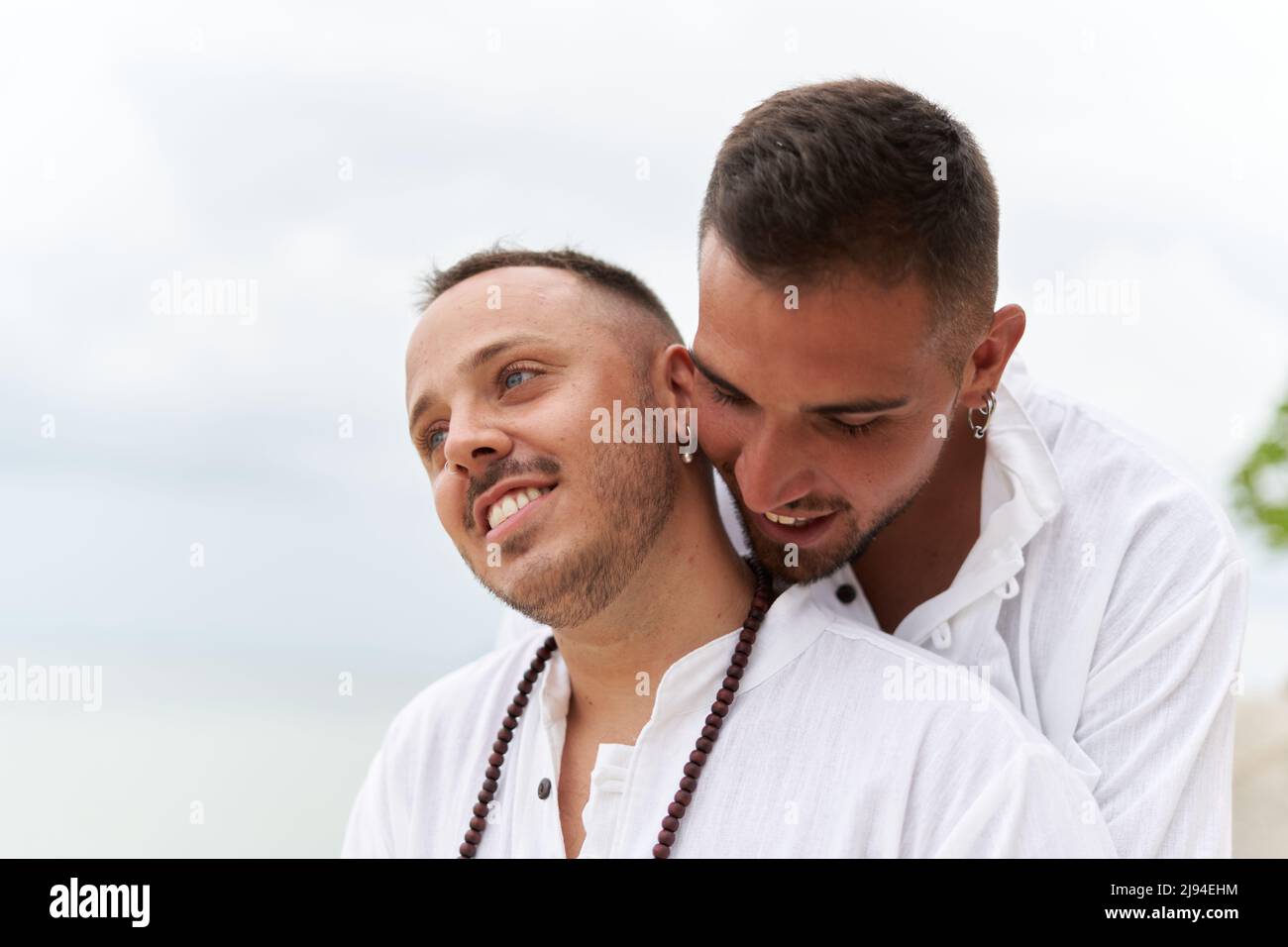 Primo piano foto di una coppia gay innamorata che si abbraccia su una spiaggia Foto Stock