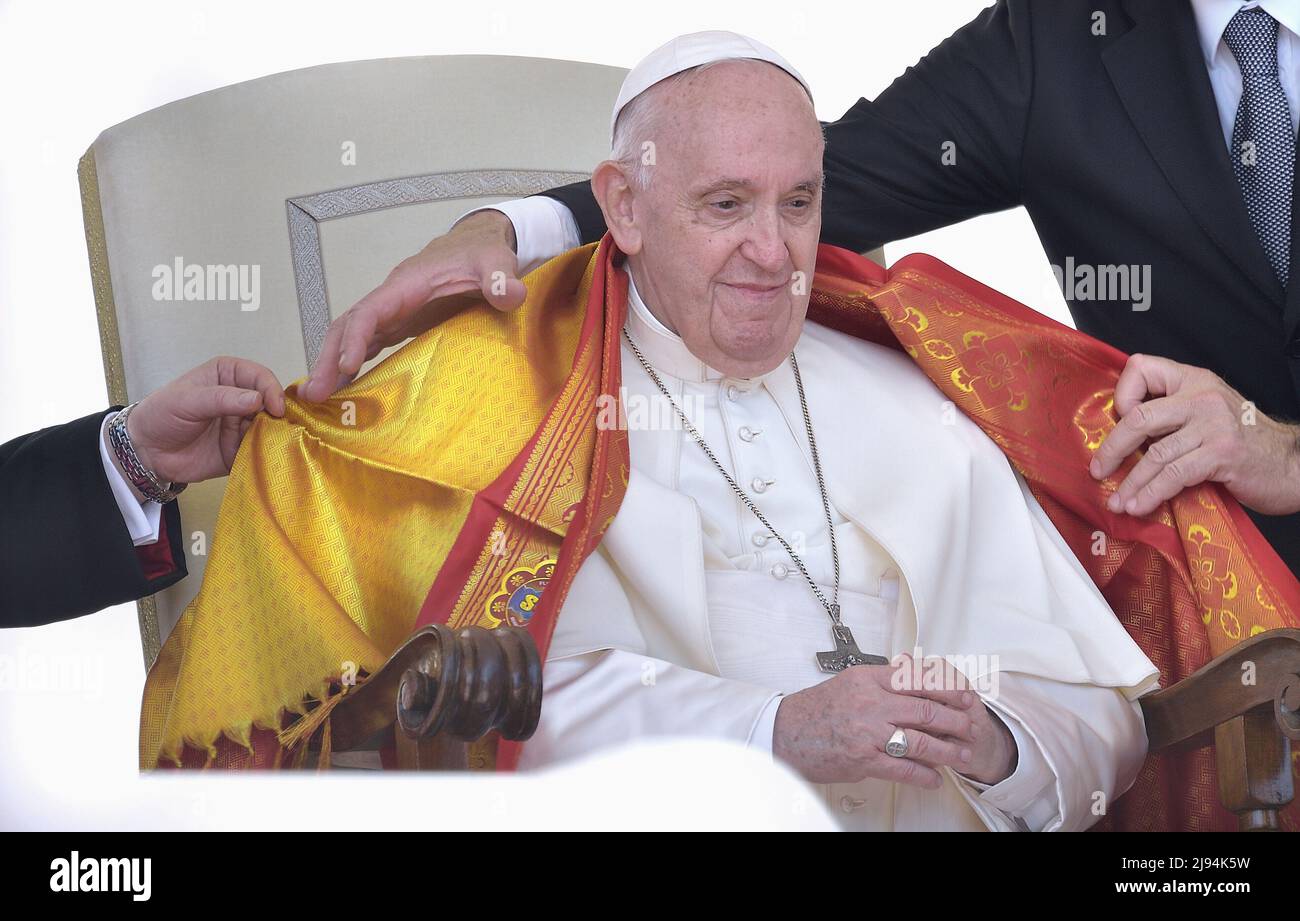 Città del Vaticano, Vatikanstadt. 18th maggio 2022. Un prete indiano copre le spalle di Papa Francesco con una scialle gialla, un simbolo di rispetto e di onore.Papa Francesco durante un'udienza generale settimanale a Piazza San Pietro il 18 maggio 2022 Credit: dpa/Alamy Live News Foto Stock