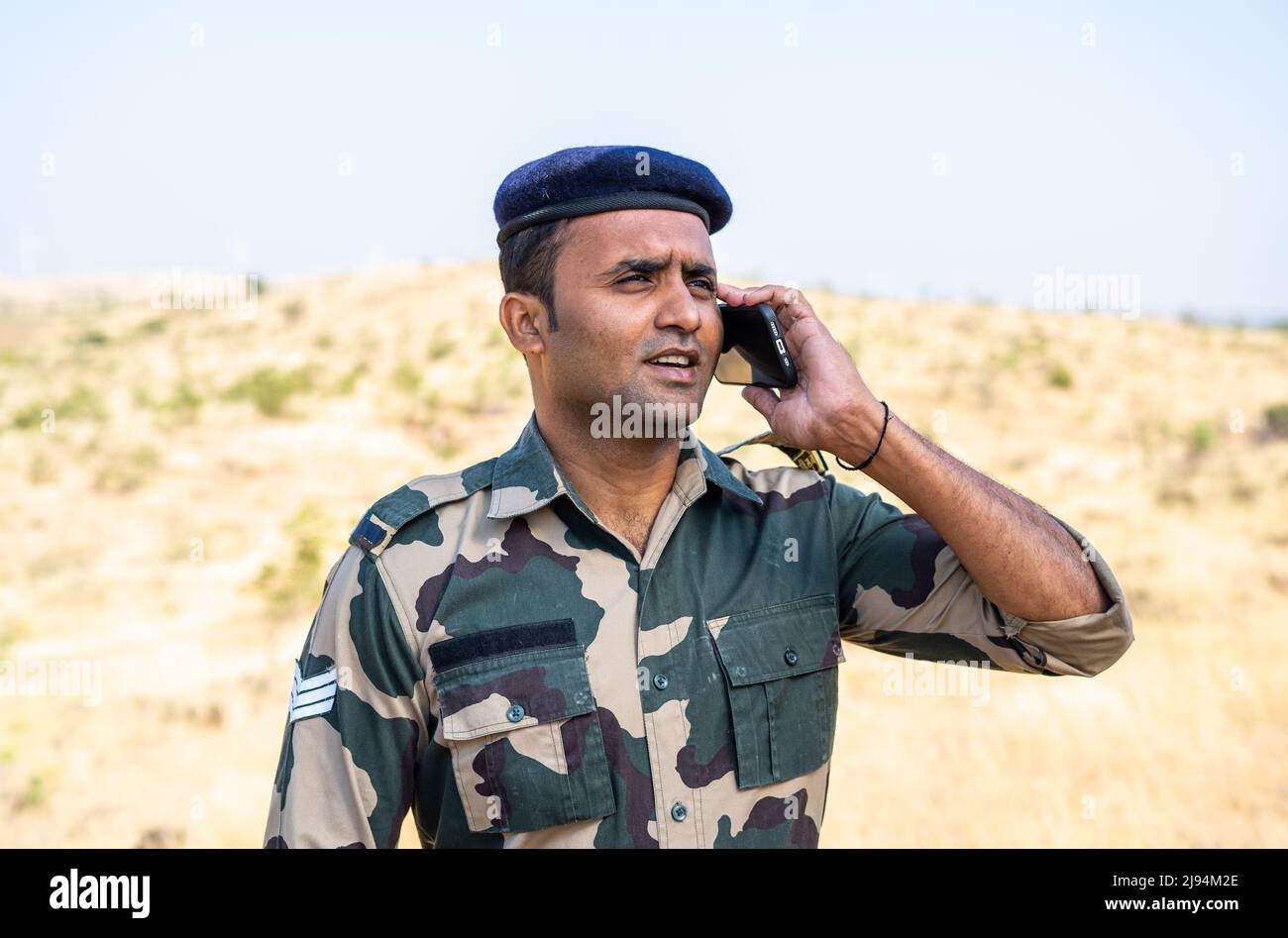 Felice soldato indiano in uniforme parlando con la famiglia - concetto di servizio in servizio, comunicazione e miising famiglia o amici Foto Stock