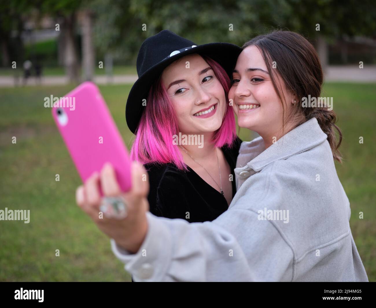 due ragazze sorridenti che prendono un selfie insieme nel parco Foto Stock