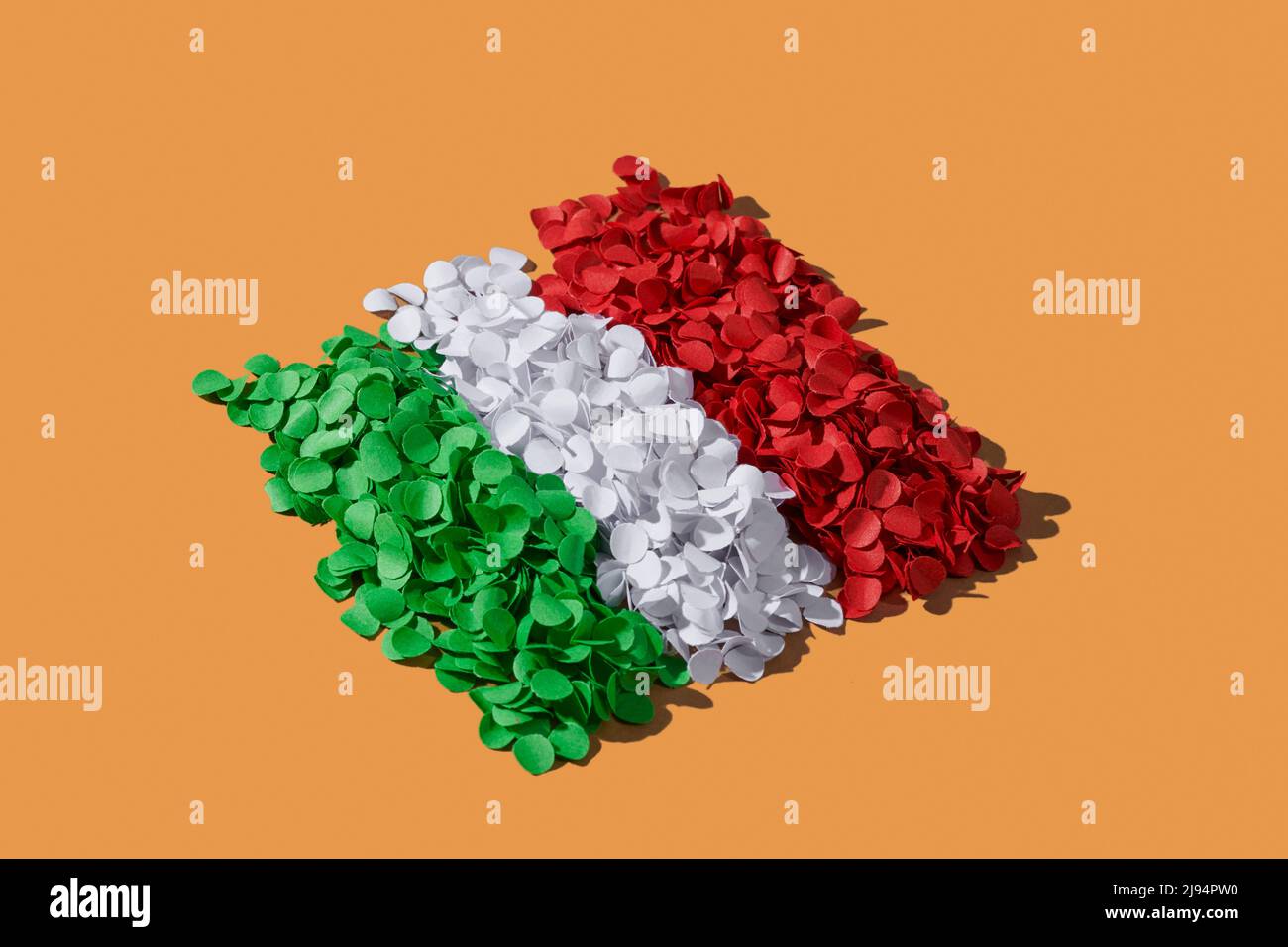 Alcune pile di confetti verdi, bianchi e rossi disposti a formare la bandiera nazionale d'Italia, su sfondo marrone Foto Stock