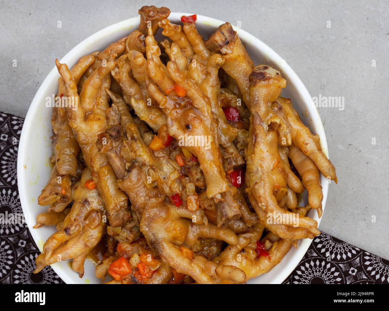 Specialità della città sudafricana, zampe di pollo cotte o walkie talkie con cipolla e salsa Foto Stock