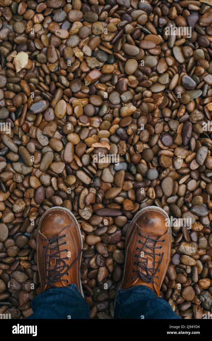 Gli stivali da uomo si trovano su una lussureggiante passerella in pietra naturale Foto Stock