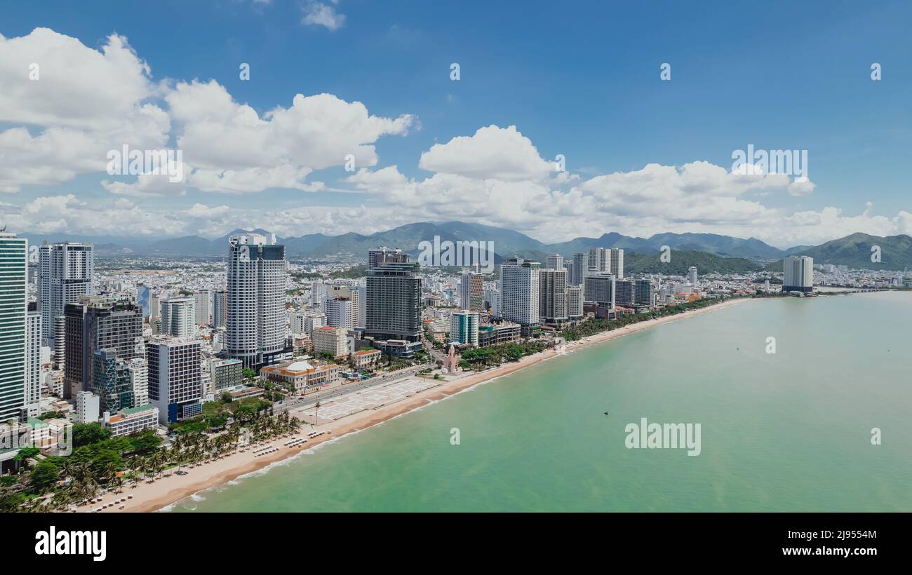 Paesaggio urbano aereo della costa di Nha Trang nella provincia di Khanh Hoa del Vietnam in una giornata estiva soleggiata piena di hotel e turisti sulla spiaggia Foto Stock