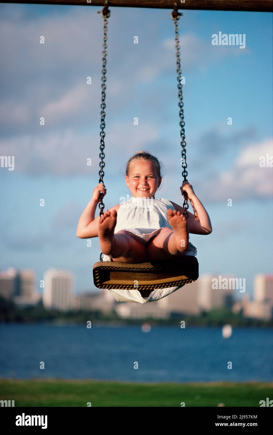 Australia. Riverside Park. Bambini. Ragazza su un swing. Foto Stock
