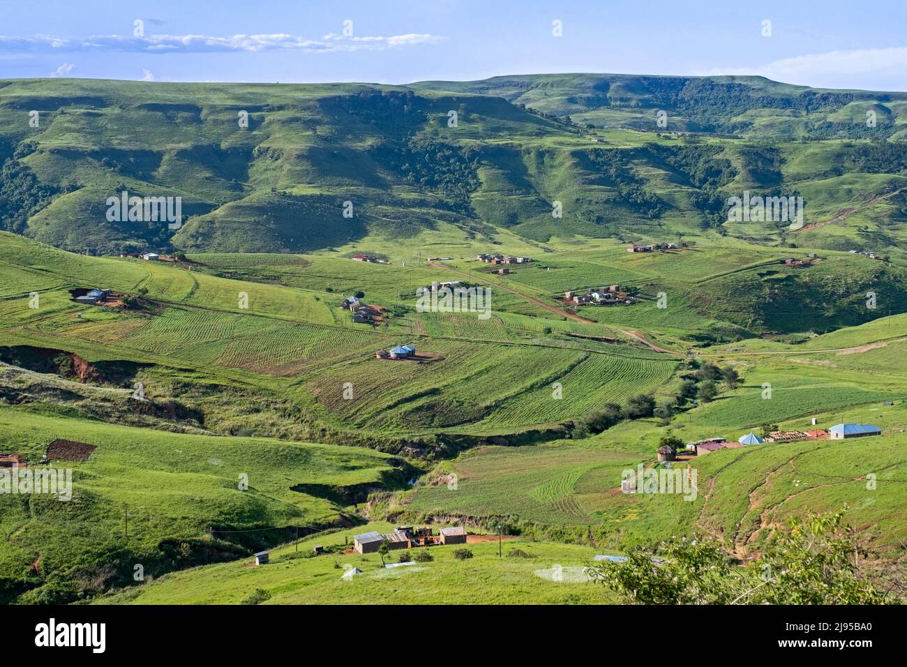 Drakensberg Mountain Range e insediamento rurale nella campagna della zona di Injisuthi a KwaZulu-Natal, Sudafrica Foto Stock