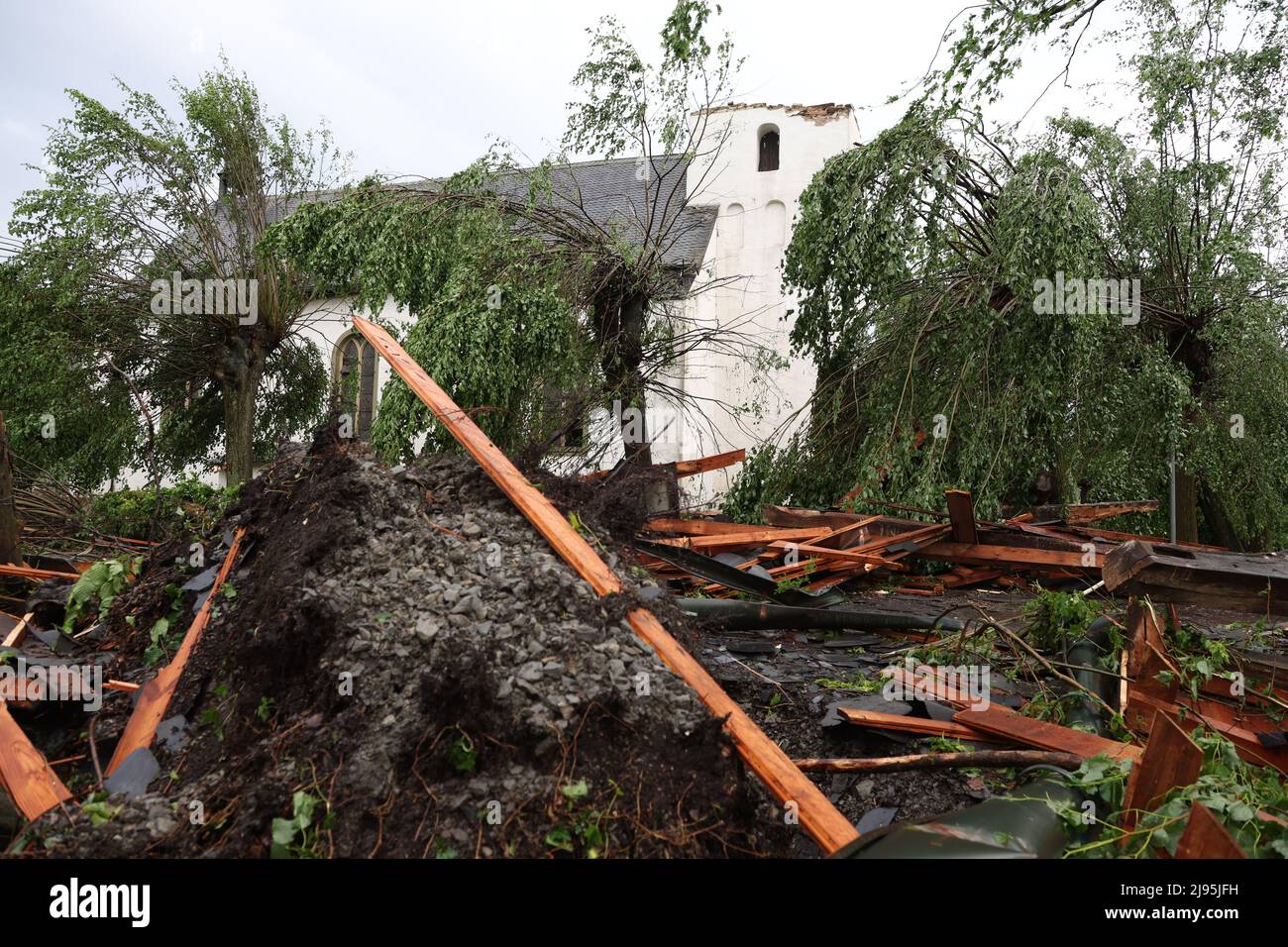 Lippstadt, Germania. 20th maggio 2022. I detriti si trovano di fronte alla Chiesa cattolica di San Clemente a Hellinghausen, vicino a Lippstadt, la cui guglia è stata distrutta. Un presunto tornado ha causato danni enormi a Lippstadt il venerdì pomeriggio. Credit: Friso Gentsch/dpa/Alamy Live News Foto Stock