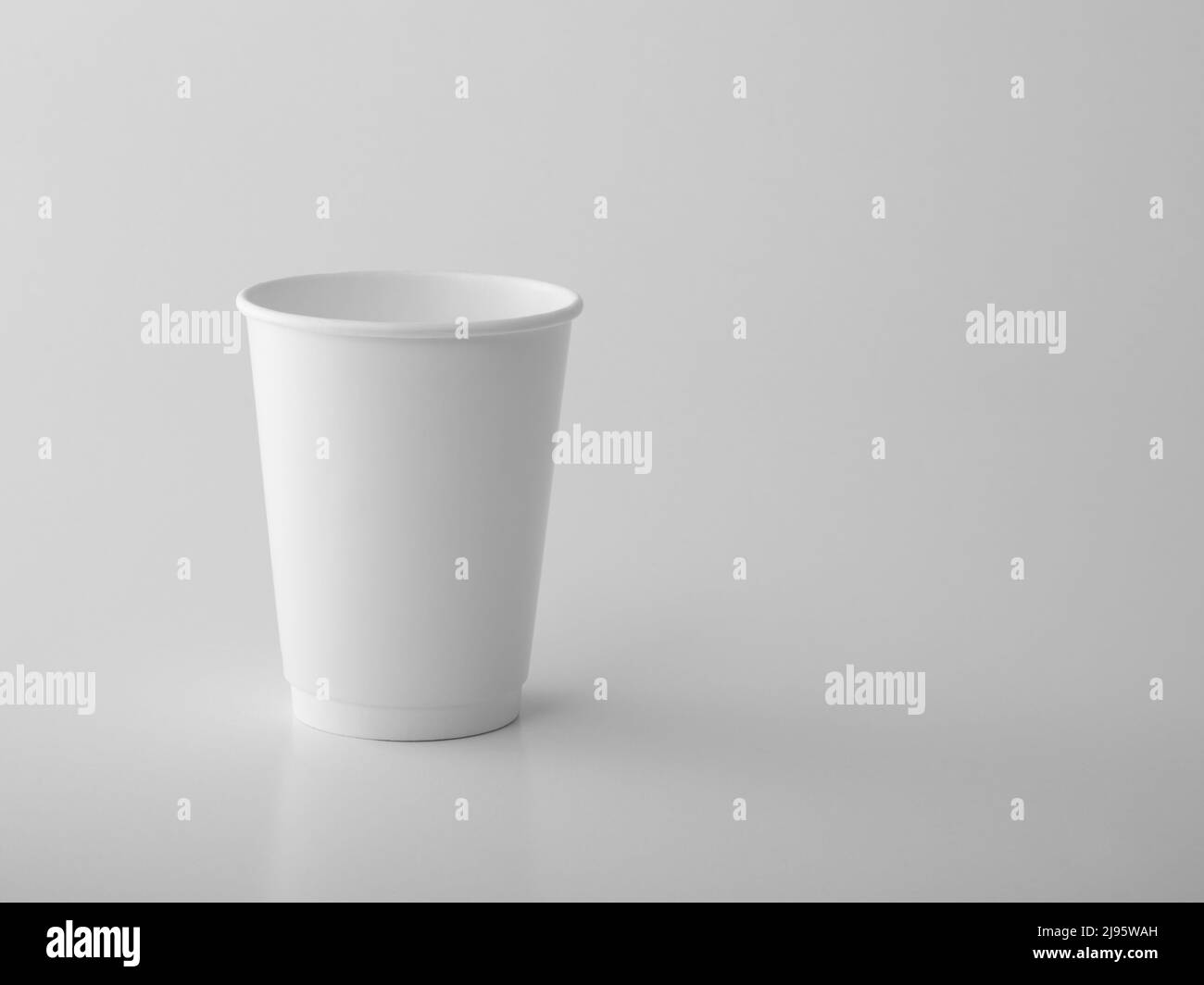 Tazza di carta bianca da asporto su sfondo bianco. Foto Stock