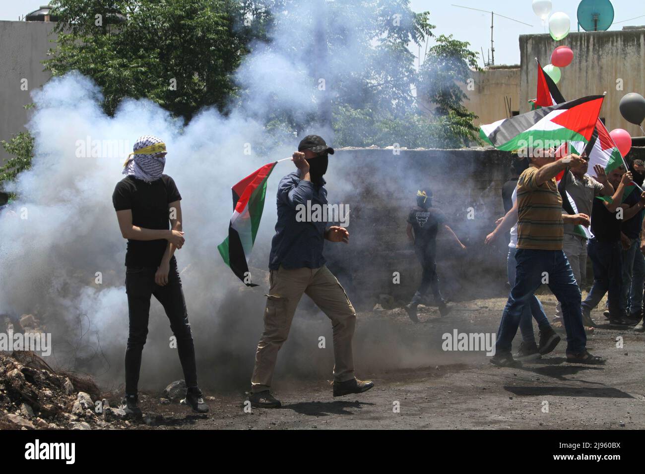 Nablus, Palestina. 12th maggio 2022. I manifestanti palestinesi hanno fatto esplodere bandiere come una bomba sonora durante la manifestazione contro gli insediamenti israeliani nel villaggio di Kafr Qaddum, vicino alla città di Nablus, in Cisgiordania. Credit: SOPA Images Limited/Alamy Live News Foto Stock
