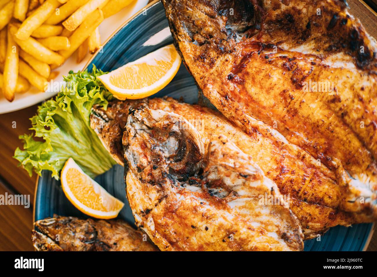 Piatto con orata alla testa di dorata Pesce con arancia e patatine fritte. Dorada, Dorade, dorado, Dourada fish and chips Foto Stock