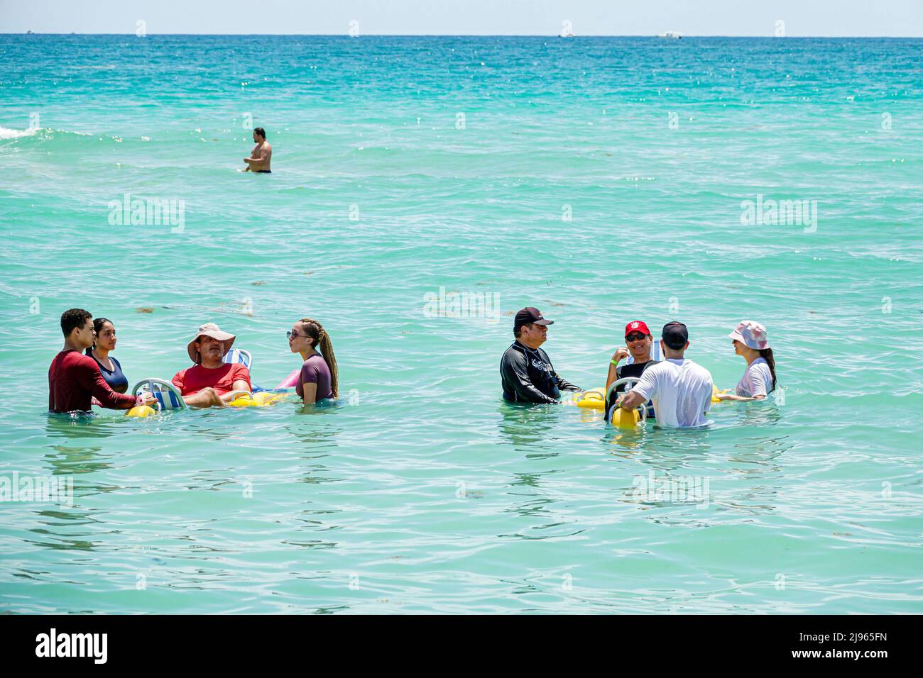 Miami Beach Florida, Sabrina Cohen Adaptive Beach Day, disabili esigenze speciali disabili waterwheels galleggianti sedia a rotelle, uomo ispanico donna maschile Foto Stock