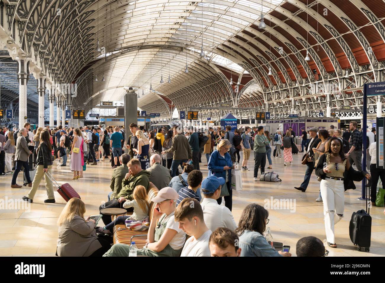 Pendolari serali e passeggeri in attesa sull'atrio della stazione di Londra Paddington per i loro treni, Regno Unito Foto Stock
